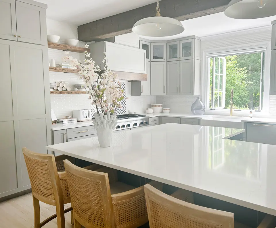 Kitchen with large white island and three bar stools